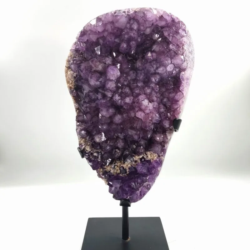 Géode d’améthyste naturelle montée sur un support métallique noir, présentant de nombreux cristaux violets brillants aux reflets translucides, formant une structure minérale éclatante.