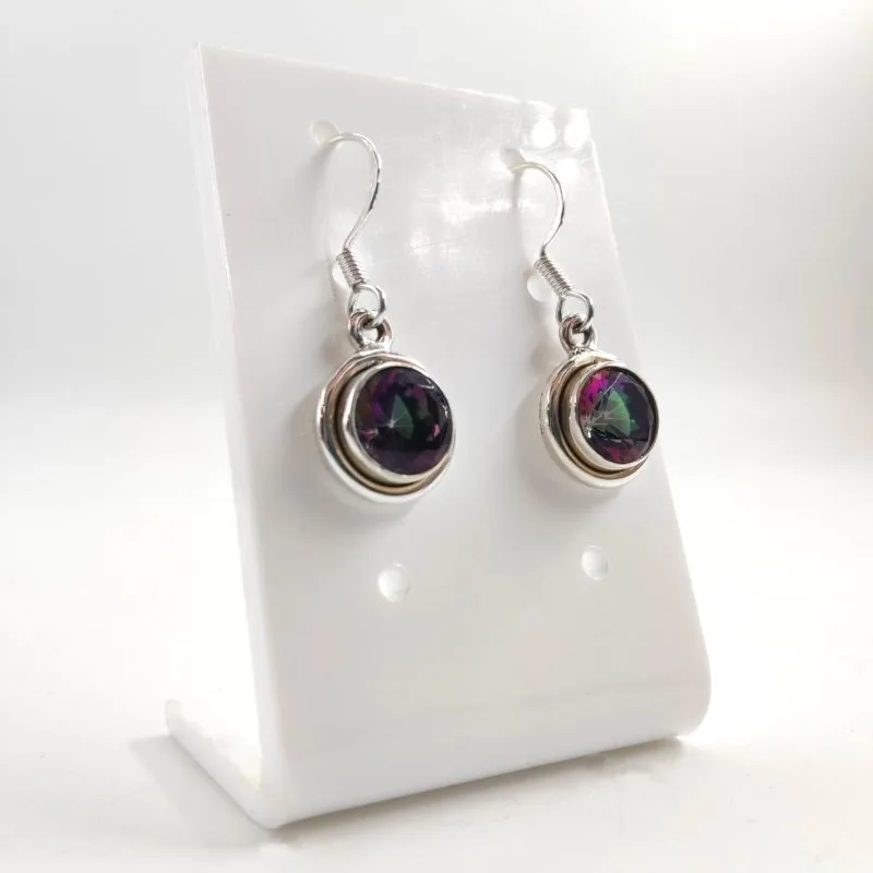 Paire de boucles d’oreilles pendantes en argent, ornées de pierres rondes facettées aux reflets multicolores violet et vert, présentées sur un support blanc.