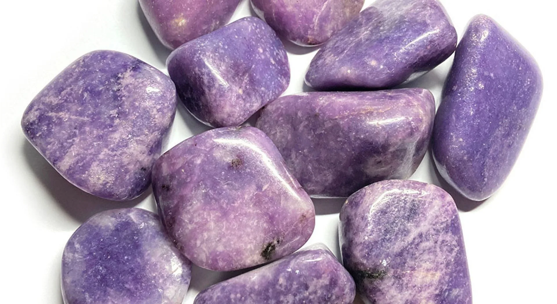 Pierres roulées en lépidolite, minéral violet aux nuances lavande et lilas, présentant une surface polie et brillante.