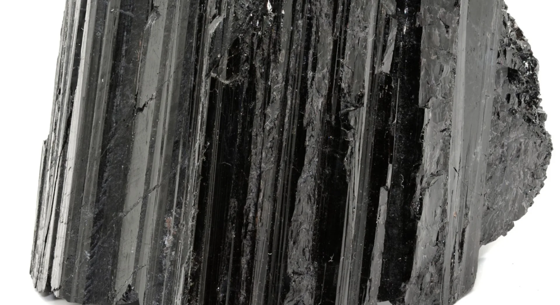 Cristal brut de tourmaline noire, pierre de protection aux stries verticales brillantes et surface naturelle.